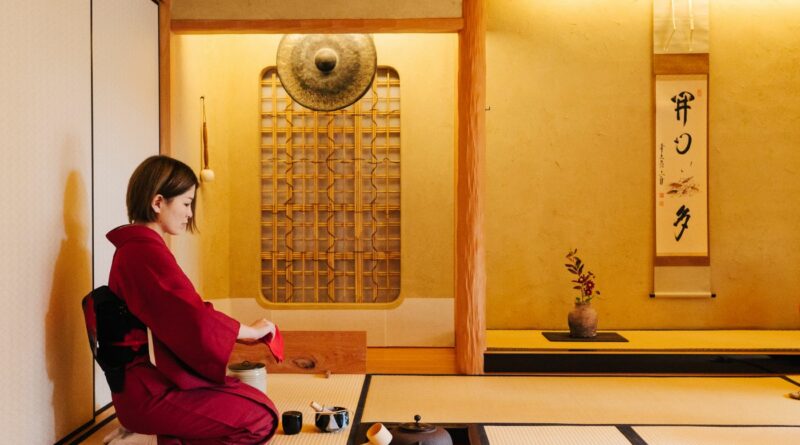 A woman kneeling to serve tea in a Japanese style room.